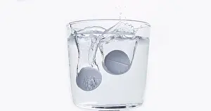 Full Body Length Tablet Drop Prints: Tablets Falling and Dissolving into a Glass of Water against White Background