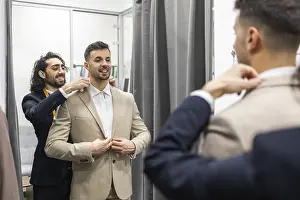 Professional Tailor Service Prints: A tailor skillfully adjusts a client suit jacket in a fitting room