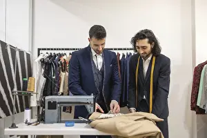 Fashion Design Prints: Tailor in a suit store work on fabric with precision