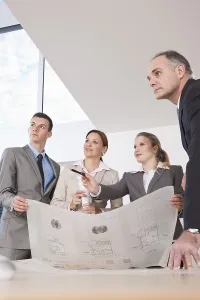 Architect Construction Plan Prints: Team of four architects discussing an construction plan