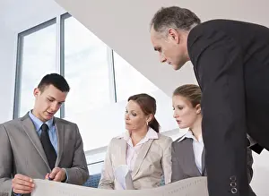 Construction Project Management Prints: Team of four architects discussing an construction plan