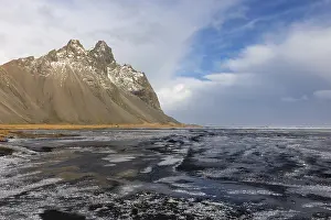 Icelandic Winter Scenery Prints: Teared water on lava sandy beach against mountain backdrop