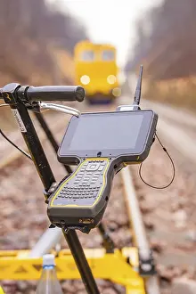 Southern Germany Train Photography Prints: A technical device with a screen on a rail surveyor in the blur of the background