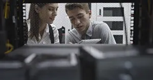 Healthcare Technology Prints: Technicians using laptop while analyzing server in server room