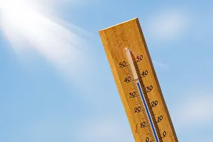 Blue Sky With Clouds Image Prints: Thermometer with a high temperature reading on a scale