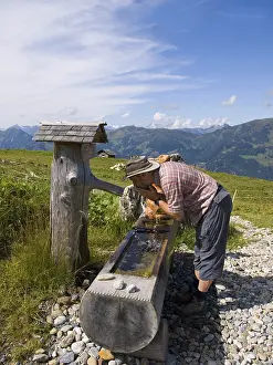 Mountainous Leisure Activity Prints: Thirsty hiker drinking from a well