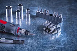 Metallic Background Concept Prints: Toolset of screwdriver with stainless replaceable bits and torx on scratched metallic background construction concept
