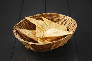 Traditional Breakfast Dish Prints: Tortilla cut on triangular slices in wicker backet on a table