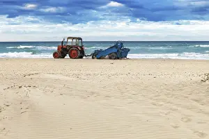 Deserted Beach Scenery Prints: Tractor on the sandy beach cleaning