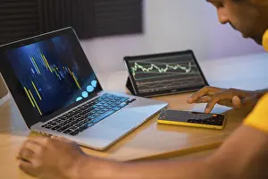 Man Working From Home Prints: Trader using computer and electronic devices to work in remote from home
