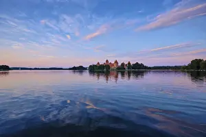 Prints of Trakai Island Castle in lake Galve, Lithuania on sunset with dramatic sky reflecting in water. Trakai Castle is one of major tourist attractions of Lithuania Lake Prints: Trakai Island Castle Print at Sunset, Lithuania