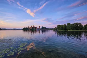 Prints of Trakai Island Castle in lake Galve, Lithuania on sunset with dramatic sky reflecting in water, Trakai Castle is one of major tourist attractions of Lituania Lake Prints: Trakai Island Castle Print, Lithuania