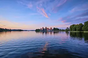 Prints of Trakai Island Castle in lake Galve, Lithuania on sunset with dramatic sky reflecting in water. Trakai Castle is one of major tourist attractions of Lituania Lake Prints: Trakai Island Castle Print, Lithuania at Sunset