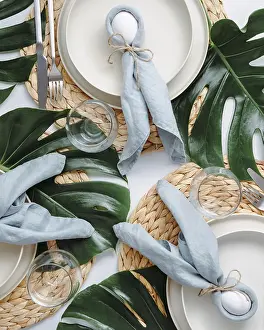 Easter Food Photography Prints: Tropical Easter Tablesetting. Top view of table setting for Christian Easter with bunny eggs decorated monstera leaves