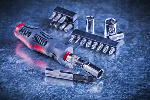 Symbolic Construction Image Prints: Turn screw with set of replaceable bits and torx on scratched metallic background construction concept
