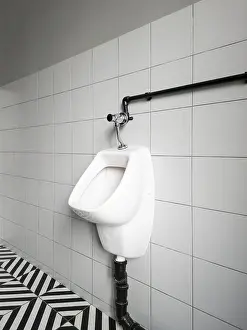 Clean Bathroom Interior Prints: A urinal is mounted on a wall in a restroom