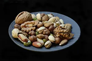 Studio Shot Of Nuts Prints: Various nuts on plates, Germany
