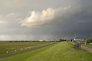 Dark Clouds Over Germany Prints: View from the dyke towards the harbour