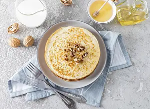 Traditional Russian Cuisine Prints: Top view of a large stack crepes of with honey and walnuts