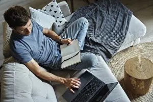 Work From Home Setup Prints: Above view of man sitting on sofa and using laptop