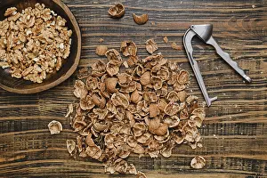 Rustic Kitchen Setting Prints: Walnuts are being shelled on a rustic wooden surface
