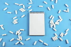 Plain Blue Background Image Prints: White Notepad on a blue background with tablets