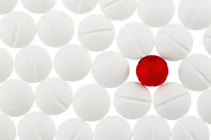 Austria Healthcare System Prints: White tablets in contrast with a red tablet