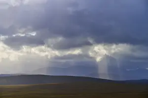 Light Beam Photography Prints: Wide landscape with rolling hills and rays of light falling through clouds