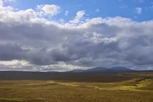 Northern Europe Countryside Prints: Wide plain with cloudy sky and distant mountains in the background