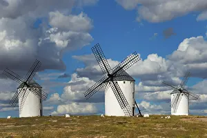 Windmills In Spain Prints: Three windmills in front of a dramatic sky with imposing clouds