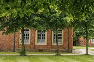 German Federal Republic Construction Prints: Window of a brick building, framed by green trees