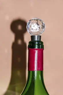 Alcoholic Beverage Images Prints: A wine bottle with cap casts shadows on the wall