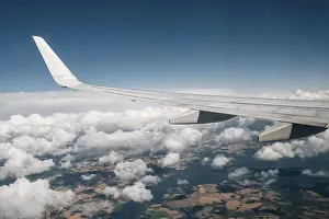 Aviation Industry Images Prints: Wing of an airplane flying above the clouds