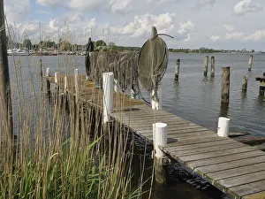 Cloudy Sky Europe Prints: Wooden jetty with nets and posts