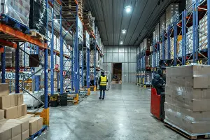 Teamwork In Industry Prints: Workers are moving inventory using a forklift