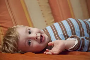 Young Boy On Sofa Prints: Young boy lying on a sofa