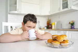 Cozy Breakfast Atmosphere Prints: A young boy sits at a kitchen table