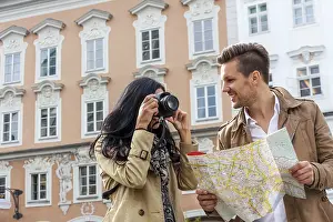 Prints of Young couple with city map and travel guide while visiting a city on holiday Austria Map Prints: Young Couple with City Map and Travel Guide Print, Austria