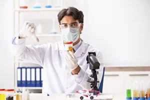 Handsome Chemist Prints: Young handsome chemist working in the lab