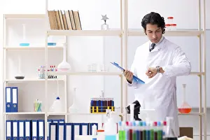 Laboratory Experiment Prints: Young handsome chemist working in the lab