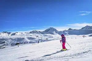 Prints of Young kid, girl skiing down on a ski slope. Sunny day on ski winter holidays in Andorra, El Tarter, Pyrenees Mountains Andorra Prints: Young Girl Skiing Down a Slope Print