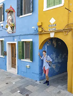 Burano Island Italy Prints: Young man with backpack in a passageway