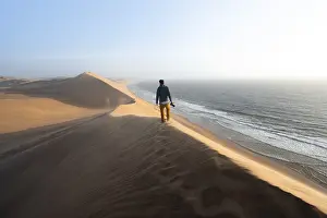 Atlantic Coast Scenery Prints: Young man with camera standing on a dune