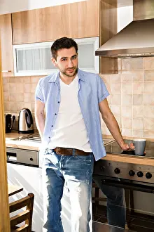 Coffee Cup Image Prints: Young man in the kitchen