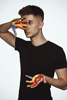 Caucasion Ethnicity Man Prints: A young man with multi-colored paint on his hands