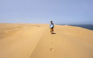 Namib Naukluft Park Scenery Prints: Young man between sand dunes with wave patterns