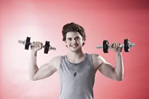 Fitness Training Equipment Prints: Young man using dumbbells during strength training