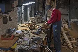 Young Man In Workshop Prints: Young man working in his workshop in the evening