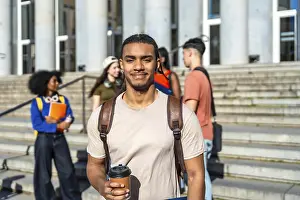 Educational Institution Photos Prints: Young multiracial student drinking coffee