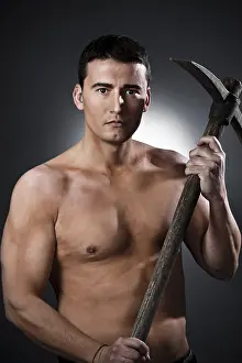 Young Worker Prints: Young worker with pickaxe over black background